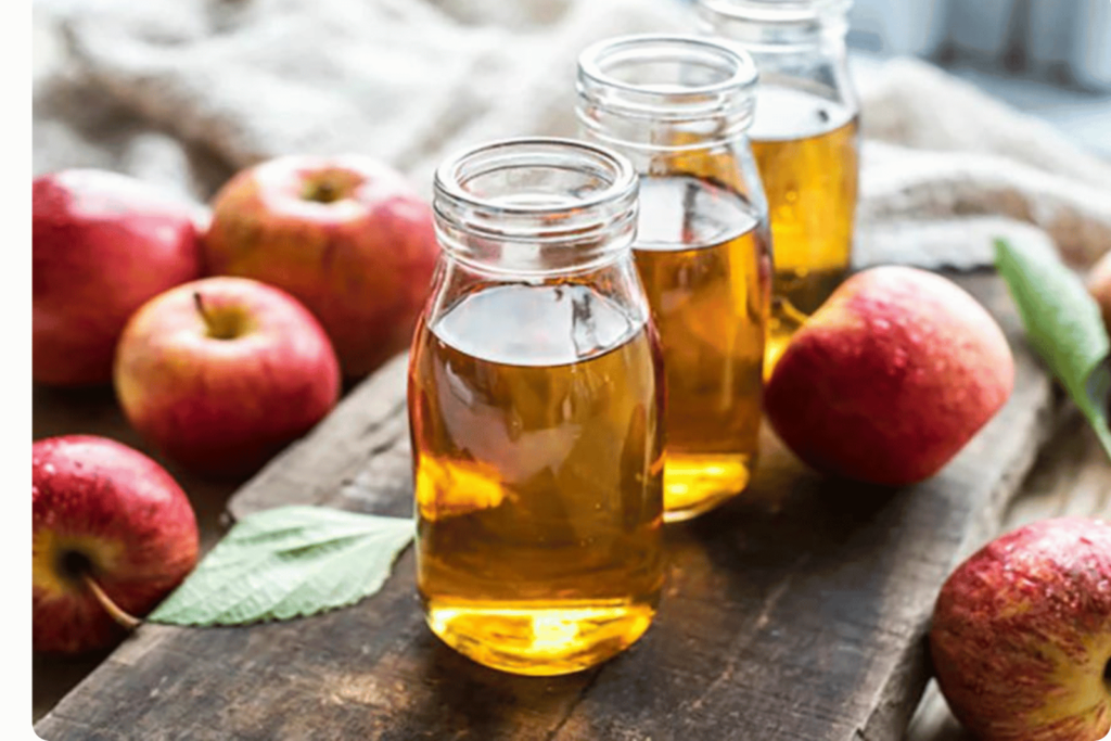 Apple cider vinegar with apples in background